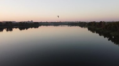 Günbatımlı akşam manzarası. Nehir ve güneş yukarıdan. Bir yaz akşamında insansız hava aracıyla manzara