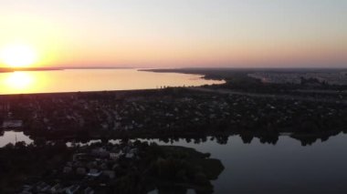 Günbatımlı akşam manzarası. Nehir ve güneş yukarıdan. Bir yaz akşamında insansız hava aracıyla manzara