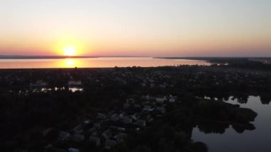 Günbatımlı akşam manzarası. Nehir ve güneş yukarıdan. Bir yaz akşamında insansız hava aracıyla manzara