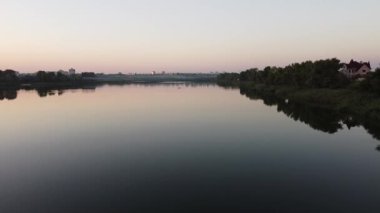 Günbatımlı akşam manzarası. Nehir ve güneş yukarıdan. Bir yaz akşamında insansız hava aracıyla manzara