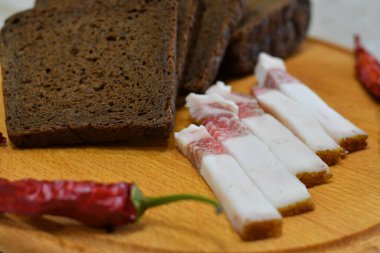 Bir parça siyah çavdar ekmeği ve pastırma. Domuz yağı ve acı biber.