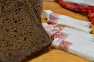 Bir parça siyah çavdar ekmeği ve pastırma. Domuz yağı ve acı biber.