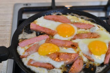 Tavada sosisli çırpılmış yumurta. Tavada kızarmış sosis..