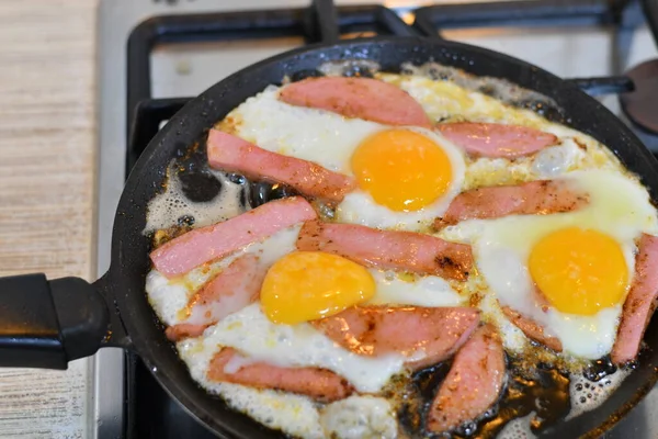 scrambled eggs with sausage in a pan. fried sausage in a pan.