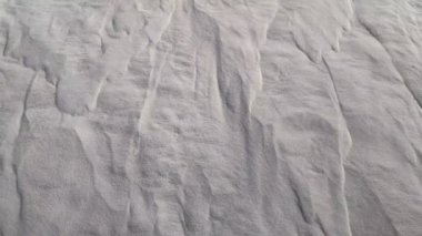 Beyaz kumla kaplı bir manzara. Beyaz kuvars kumu. Kumullar ve çöl sütyenleri