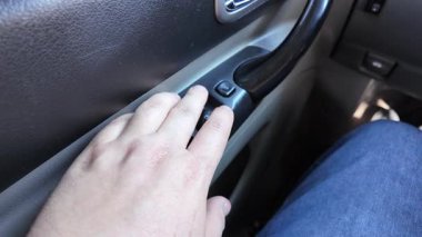 Analog pencere kaldırma düğmeleri. Adam arabanın camını açıyor. Arabadaki eski düğmeler. Adam pencereyi açma düğmesine basıyor. Pencere kaldırıcı. Bir araba düğmesindeki pencere kaldırıcıları