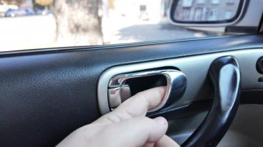 El ile arabanın kapısını açan genç adam. Bir yolcu mavi bir arabanın kapısını açar, arka koltuğa oturur ve kapıyı kapatır.,