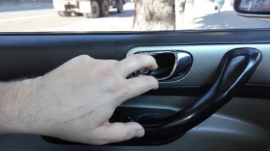 El ile arabanın kapısını açan genç adam. Bir yolcu mavi bir arabanın kapısını açar, arka koltuğa oturur ve kapıyı kapatır.,