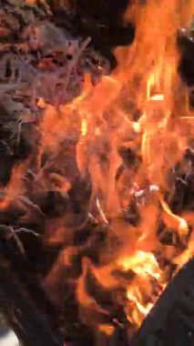 Yakacak odun yakıyor. Ağır çekim ve alevlerle ızgarada yanan çok sıcak kömürün yakın çekimi. Yakın plan, kömürleşmiş kütükler yanıyor. Ateş alevi, rahat ev, 4K,