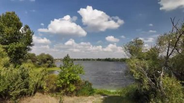 beautiful white clouds over water. video 4k 60 frames. ukrainian landscape. ukraine. dnieper river. beautiful backwater. blue lake. wide river. small waves. white clouds on blue sky