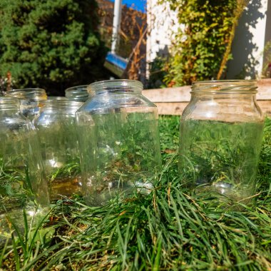 Konserve için cam kavanozlar. Boş cam kavanozlar ev konserveleri ve yiyecek depolama için bir mağaza rafına dizilmiş. Boş bir cam kavanozu tutan el.