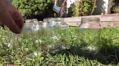 Konserve için cam kavanozlar. Boş cam kavanozlar ev konserveleri ve yiyecek depolama için bir mağaza rafına dizilmiş. Boş bir cam kavanozu tutan el.