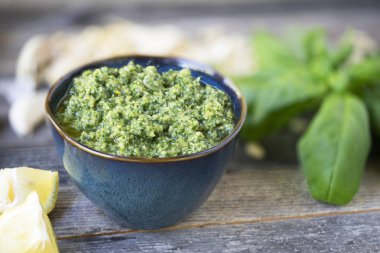 Küçük kase taze pesto pesto malzemelerle ahşap tablo