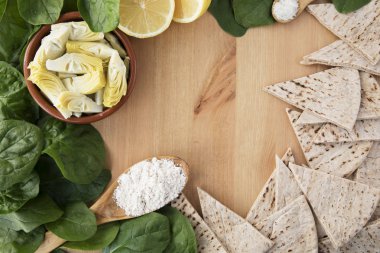 Enginar göbeği, ıspanak, limon ve diğer malzemeler için vegan düz lay kopya alanı ile daldırma