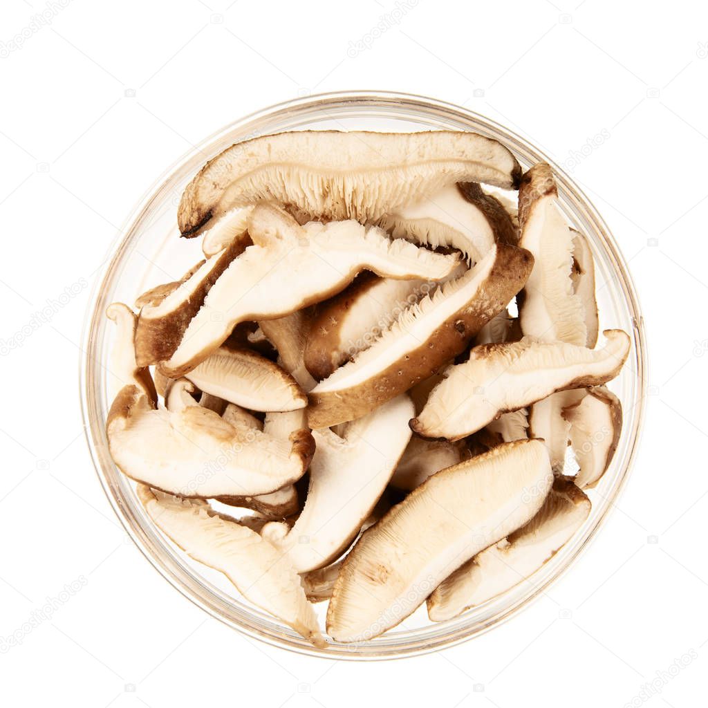 Shiitake mushroom slices in a glass bowl and isolated on a white background.