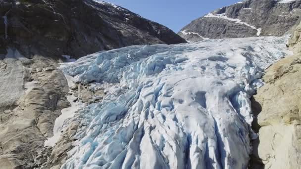 Vista aérea do glaciar Nigardsbreen no parque nacional de Nigardsvatnet Jostedalsbreen, na Noruega, em um dia ensolarado — Vídeo de Stock