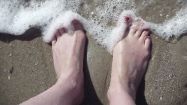 Açık deniz suyu sahilde kadın ayaklarda closeup. Ayak parmakları güzel kırmızı pedikür ile. ağır çekim