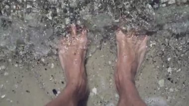 Erkek ayak plaj sahil, görünümü kadar yüksek. Deniz kıyısı üzerinde duran ayakları kapsayan su ile dostum. Yaz ve kavramlar rahatla. Ağır çekim