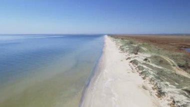 Sahil deniz dalgaları plaj mavi. Beyaz kumlu bir plaj üzerinde bulaşık berrak mavi su atış odaklanır.