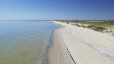 Sahil deniz dalgaları plaj mavi. Beyaz kumlu bir plaj üzerinde bulaşık berrak mavi su atış odaklanır.