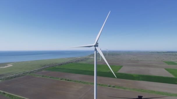 Vista aérea mirando a través de turbinas eólicas en movimiento en un día de verano — Vídeos de Stock