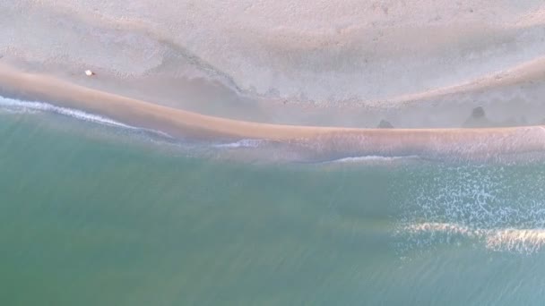 女性は、狭いビーチ行、波、海を歩いています。航空写真ビュー. — ストック動画