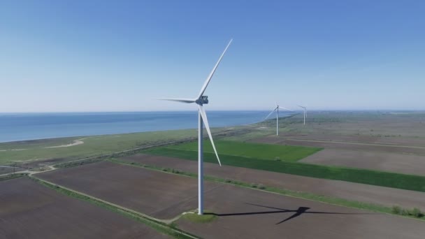 Vista aérea mirando a través de turbinas eólicas en movimiento en un día de verano — Vídeos de Stock