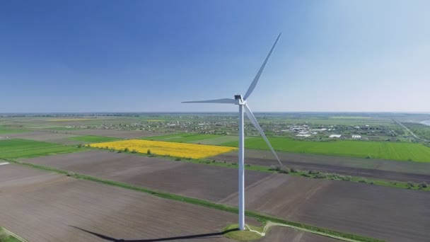 Vista aérea olhando através de turbinas eólicas em movimento em um dia de verão — Vídeo de Stock