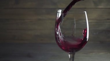 Kırmızı şarap cam ahşap arka plan içine dökülür