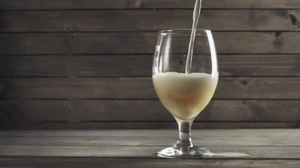 Cerveza vertida en vidrio sobre fondo de madera. Movimiento lento — Vídeo de stock