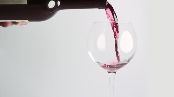 Красное вино налито в бокал — стоковое видео