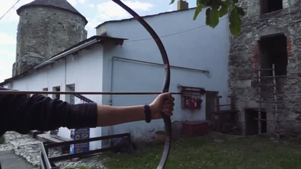 Close up shot of archer with strong hands bending mechanic bow arrow concentrating on target — Stock Video