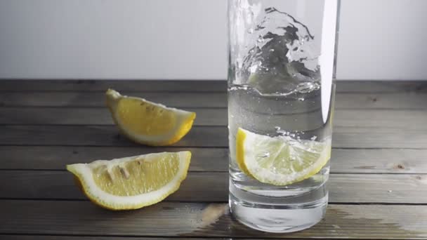 Silices de limón que caen al agua — Vídeo de stock