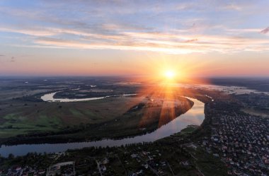 Nehri kara sevdanın turuncu günbatımı gökyüzü güzel hava görünümüne. Su ve arka plan üzerinde güneş ışınları tarafından vurgulanır