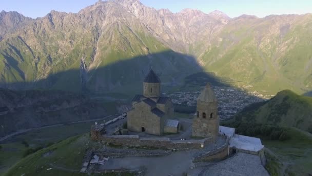 Luchtfoto. De kerk van de Gergeti op de achtergrond van de Kazbek — Stockvideo