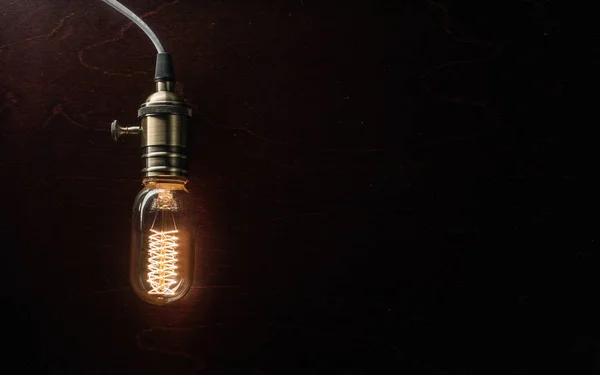 Лампочка освещается на деревянном фоне — стоковое фото