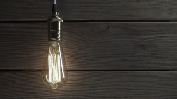 Lampadina si illumina su sfondo di legno — Video Stock