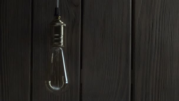 Ampoule s'illumine sur fond en bois — Video