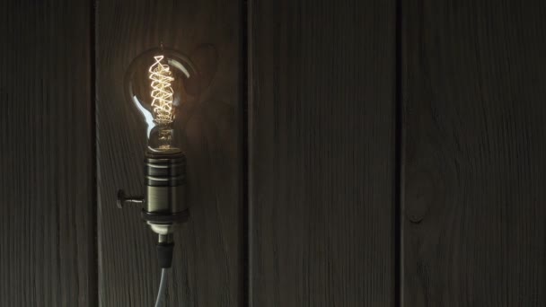 Лампочка светится на деревянном фоне — стоковое видео