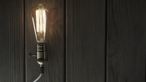 Лампочка освітлює дерев'яний фон — стокове відео
