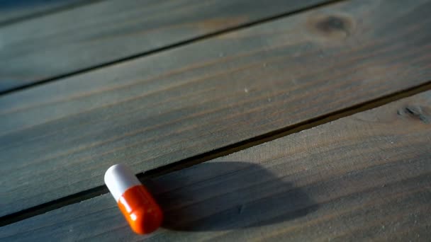Pílulas médicas derramadas sobre a mesa, em câmera lenta — Vídeo de Stock