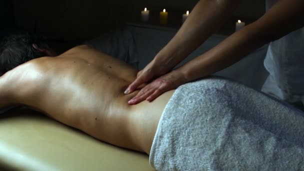 Skott av en professionell masserande massera rygg och axlar av en manlig klient. — Stockvideo