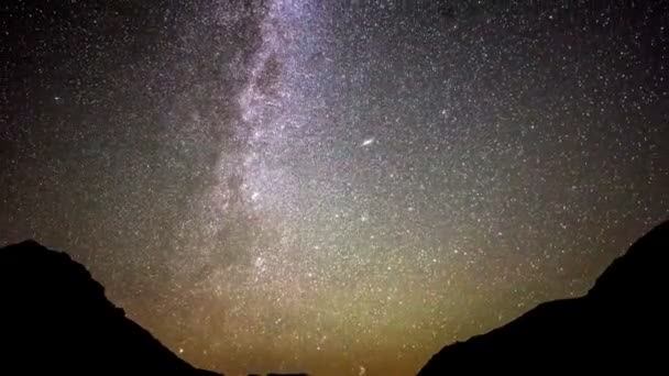 Timelapse of moving star trails in night sky (en inglés). La galaxia de la Vía Láctea girando sobre la cordillera en verano — Vídeos de Stock
