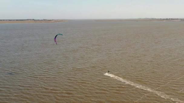Вид с воздуха на плавание кайтсерфера и прыжки через море — стоковое видео