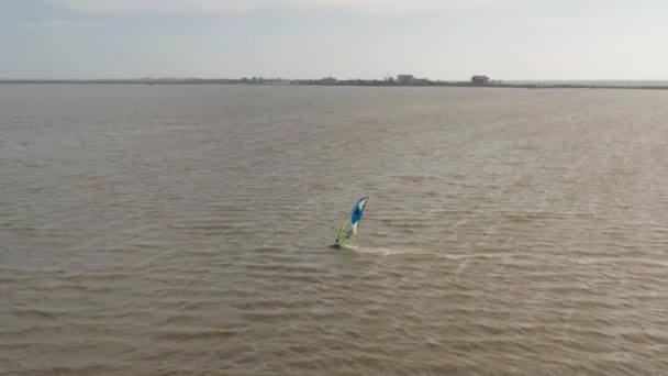 Vista aérea de kitesurfer deslizándose y saltando a través del mar — Vídeos de Stock