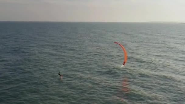 Kitesurfers paseo en olas en el verano en el mar en tiempo ventoso — Vídeos de Stock