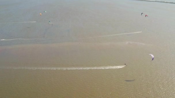 Kitesurfers paseo en olas en el verano en el mar en tiempo ventoso — Vídeos de Stock