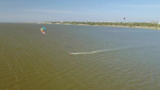 Kitesurfers paseo en olas en el verano en el mar en tiempo ventoso — Vídeos de Stock