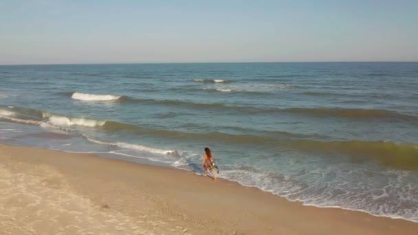 Delgada mujer deportiva está corriendo sola en la mañana temprano en la costa. cámara lenta — Vídeos de Stock