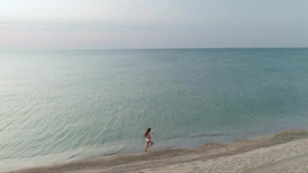 Femme sportive mince est couru seul tôt le matin sur le littoral — Video